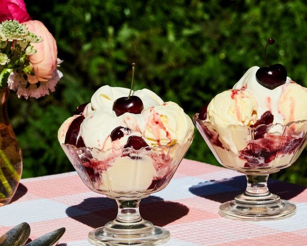 Cherries jubilee served in glass ice cream dishes on a table outside