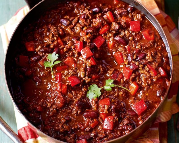 A classic chilli con carne shown in a pan on a table setting.