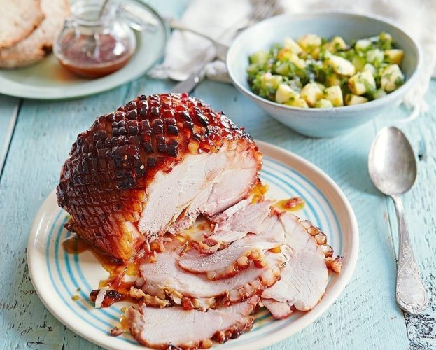 A glazed ham shown sliced and on a plate