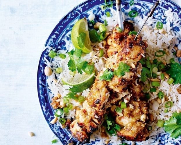 Chicken satay skewers on a blue and white plate