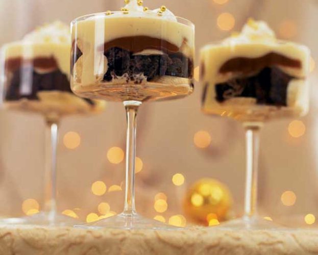 Toffee and banana trifles in tall glass stemmed bowls
