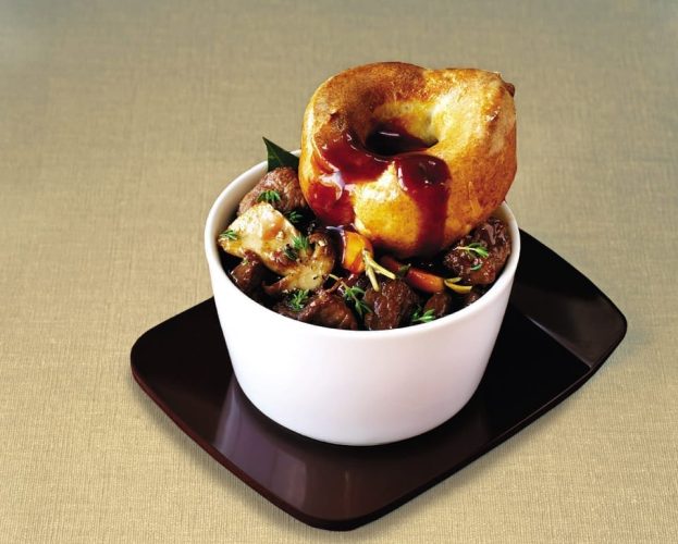 Braising steak stew with a single Yorkshire pudding on top, shown individually