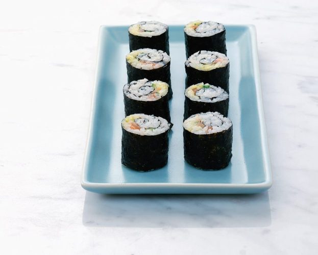 Eight complete nori-maki shown on a rectangular plate