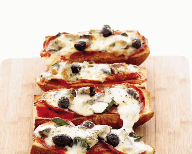 Four pizzas made with French bread, in a line