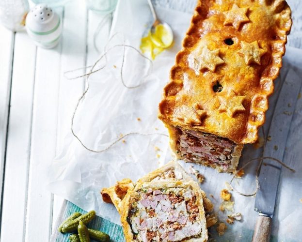 A raised picnic pie with a star decoration, shown sliced on a board