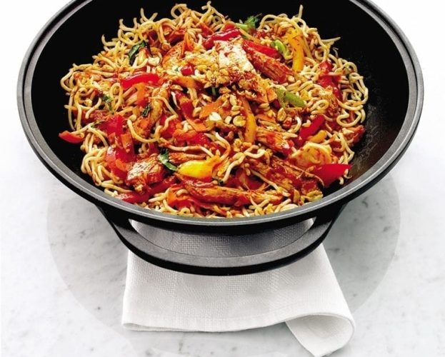 Chilli chicken noodles in a black bowl