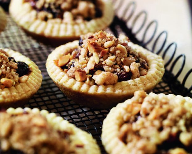 Mince pies with a streusel topping, shown in a tin