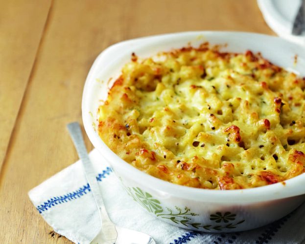 Macaroni cheese shown cooked in a white dish
