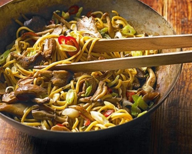 Chinese noodles with mushrooms in a wok