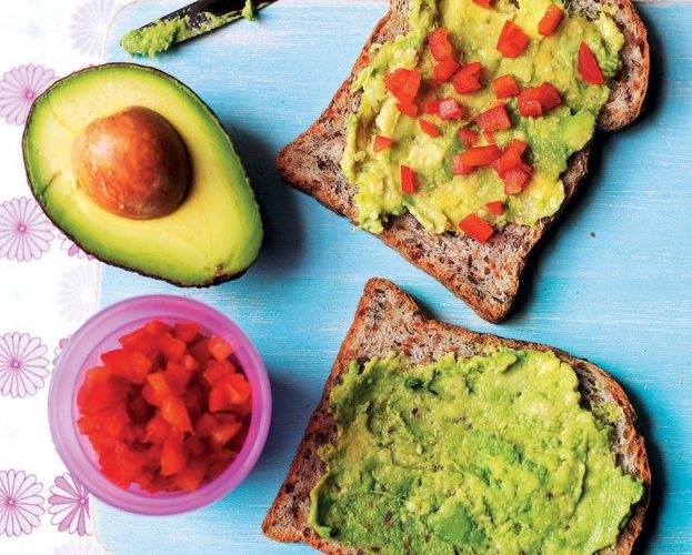 Avocado and red pepper sandwiches on a bright tablecloth