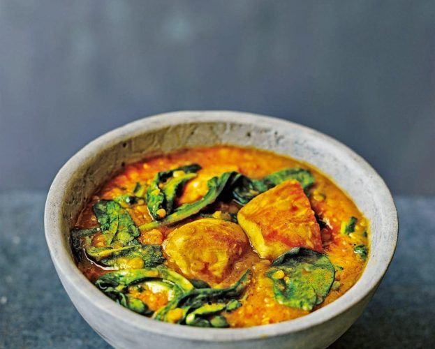 Red lentil and chicken curry shown in a blue bowl