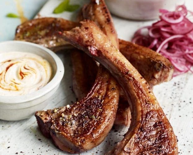 Chargrilled lamb cutlets with onions on a marble board