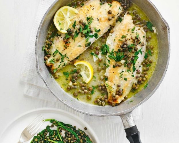 Lemon sole topped with lemon and capers, shown in a frying pan