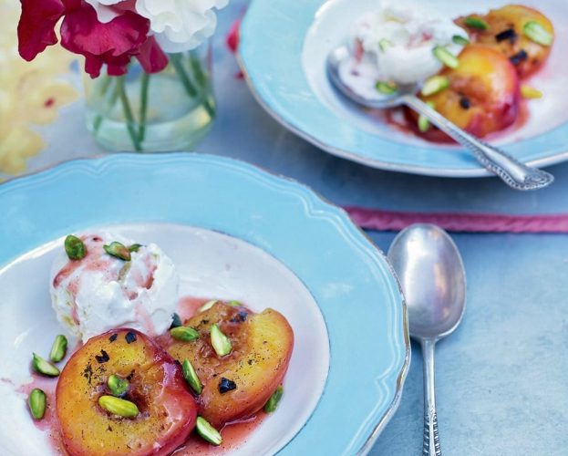 Peaches cooked on a barbecue shown on a blue plate