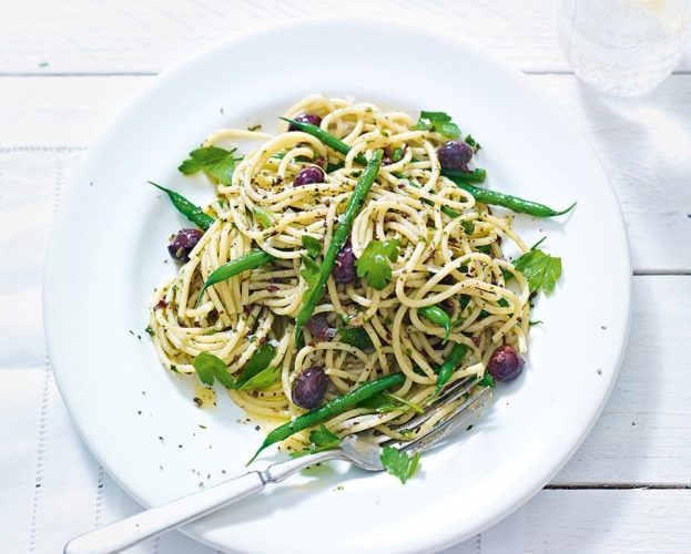 Green bean, olive tapenade pasta shown on a white plate