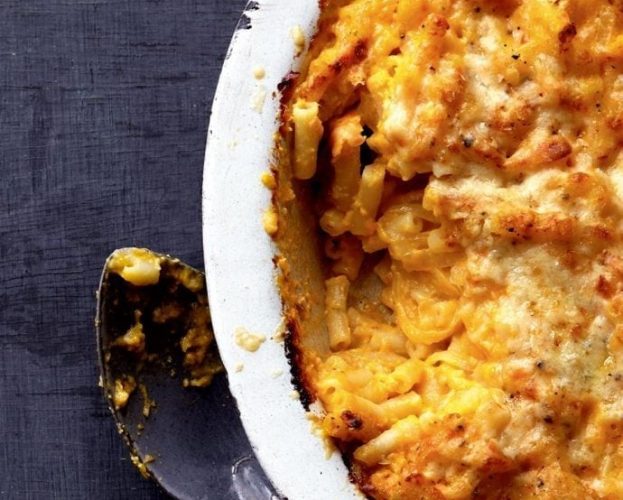 Macaroni cheese in a white bowl on a dark backgroun