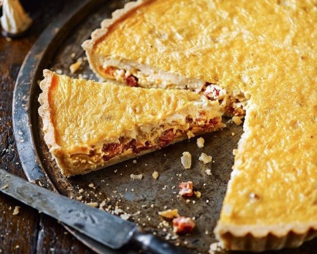 Classic quiche lorraine shown in a black tin