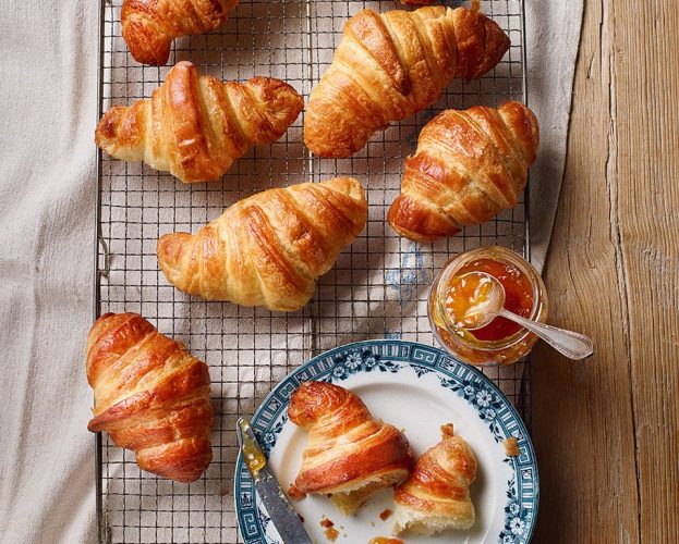 Homemade croissants shown on a wire rack