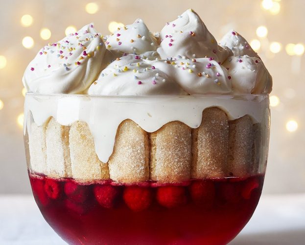 A super-decadent looking trifle with pillows of cream, shown in a glass bowl
