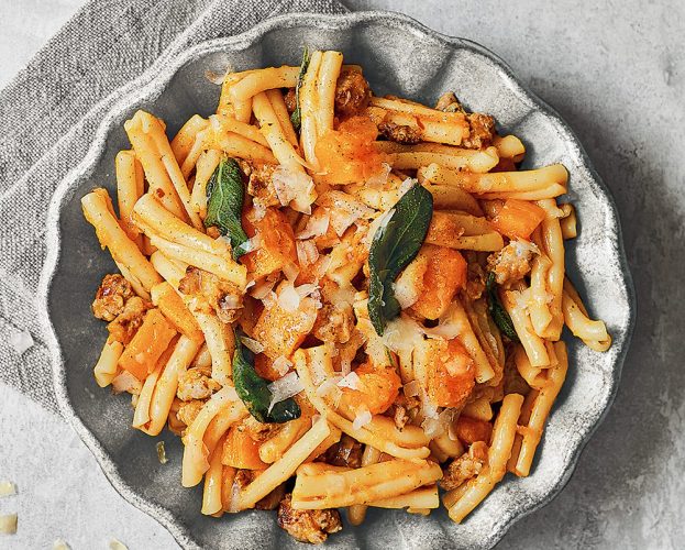 A bowl of pasta with sausage, sage and butternut squash.