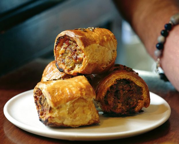 A pile of sausage rolls on a plate