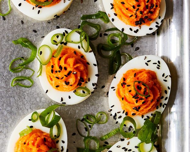 Devilled eggs topped with spring onions and black sesame seeds