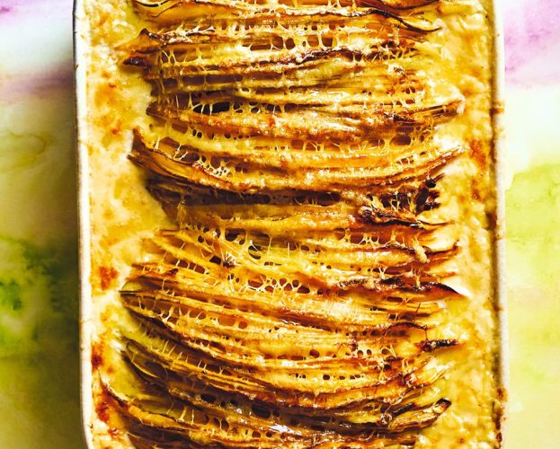 A pan of crispy hasselback-style swede slices topped with cheese