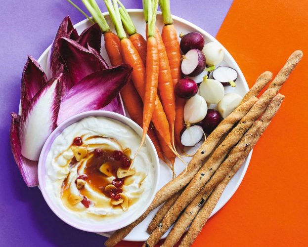A bowl of whipped goat's cheese served with crudités and breadsticks