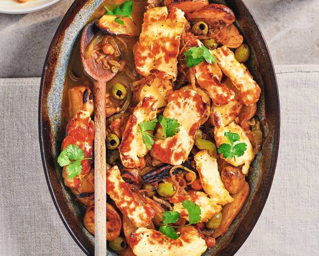 An overhead view of a dish of potato tagine, topped with golden halloumi and coriander