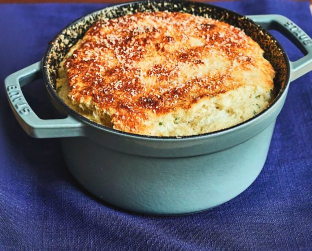 A cheddar and chive soufflé in a baking dish
