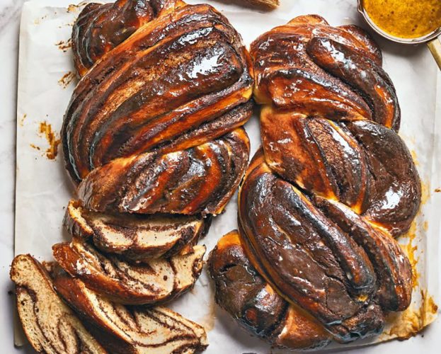 Two dark golden brioche loaves rippled with chocolate custard