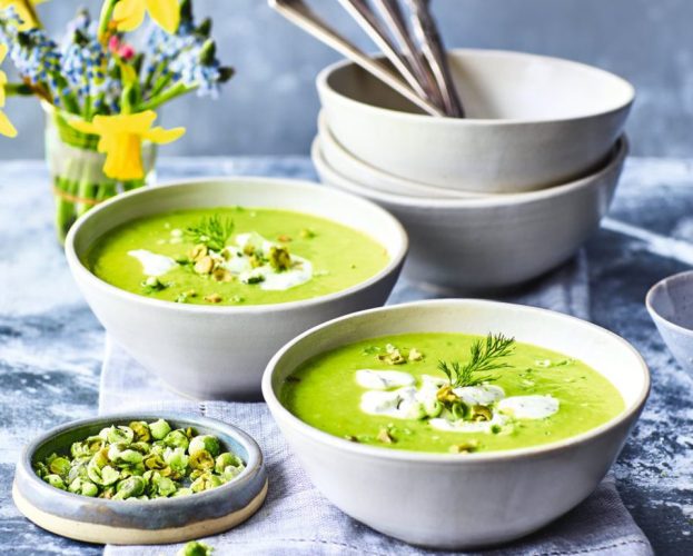 Two bowl of pea soup, topped with wasabi crème fraîche, and with wasabi peas on the side