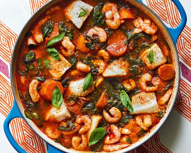 Overhead view of a sweet potato/yam pottage with prawns and greens