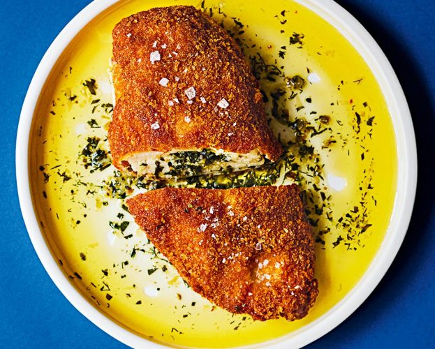 Overhead view of the best chicken kyiv, sliced in half and with garlic butter oozing