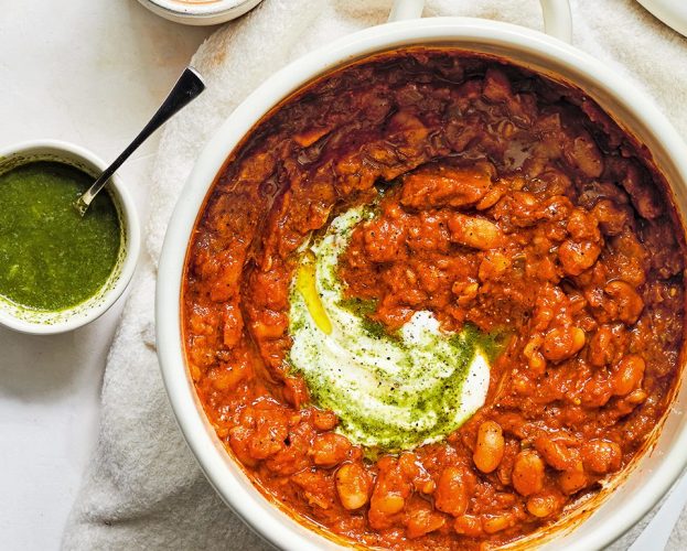 A pot of masala baked beans swirled with with green coriander chutney