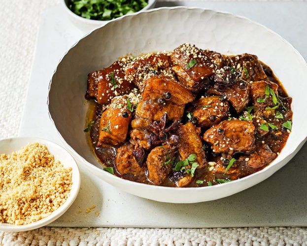 A white bowl with Southern Thai-inspired braised pork belly with peppercorns