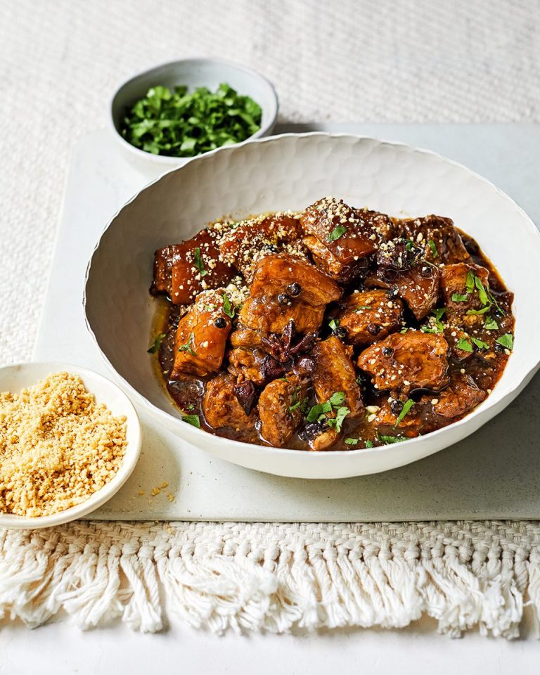 A white bowl with Southern Thai-inspired braised pork belly with peppercorns