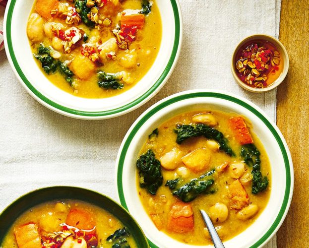 Three bowls of brothy beans with pumpkin