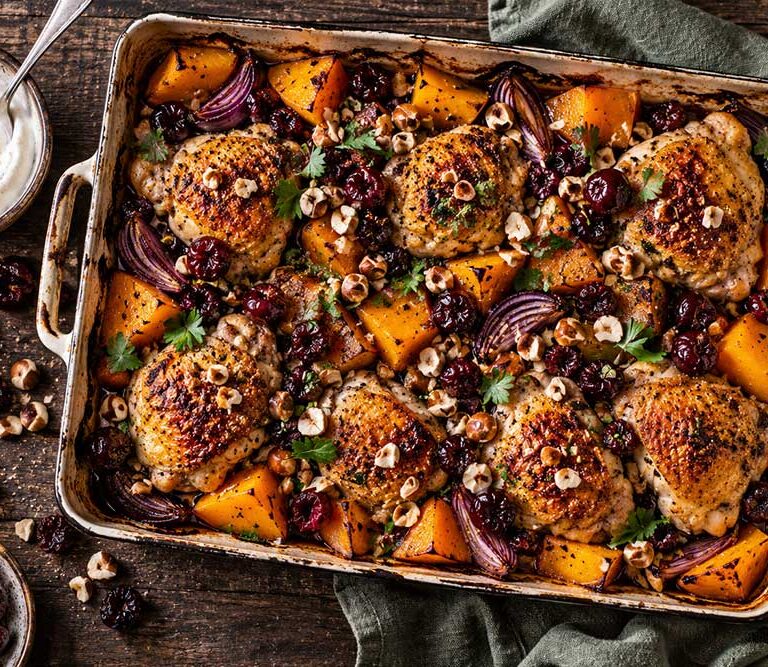 Yoghurt chicken traybake with sour cherries, roast butternut squash, red onions, hazelnuts and parsley in a roasting tin