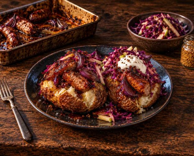 Sticky sausage jacket potatoes topped with glazed sausages, roast red onion, soured cream and red cabbage slaw